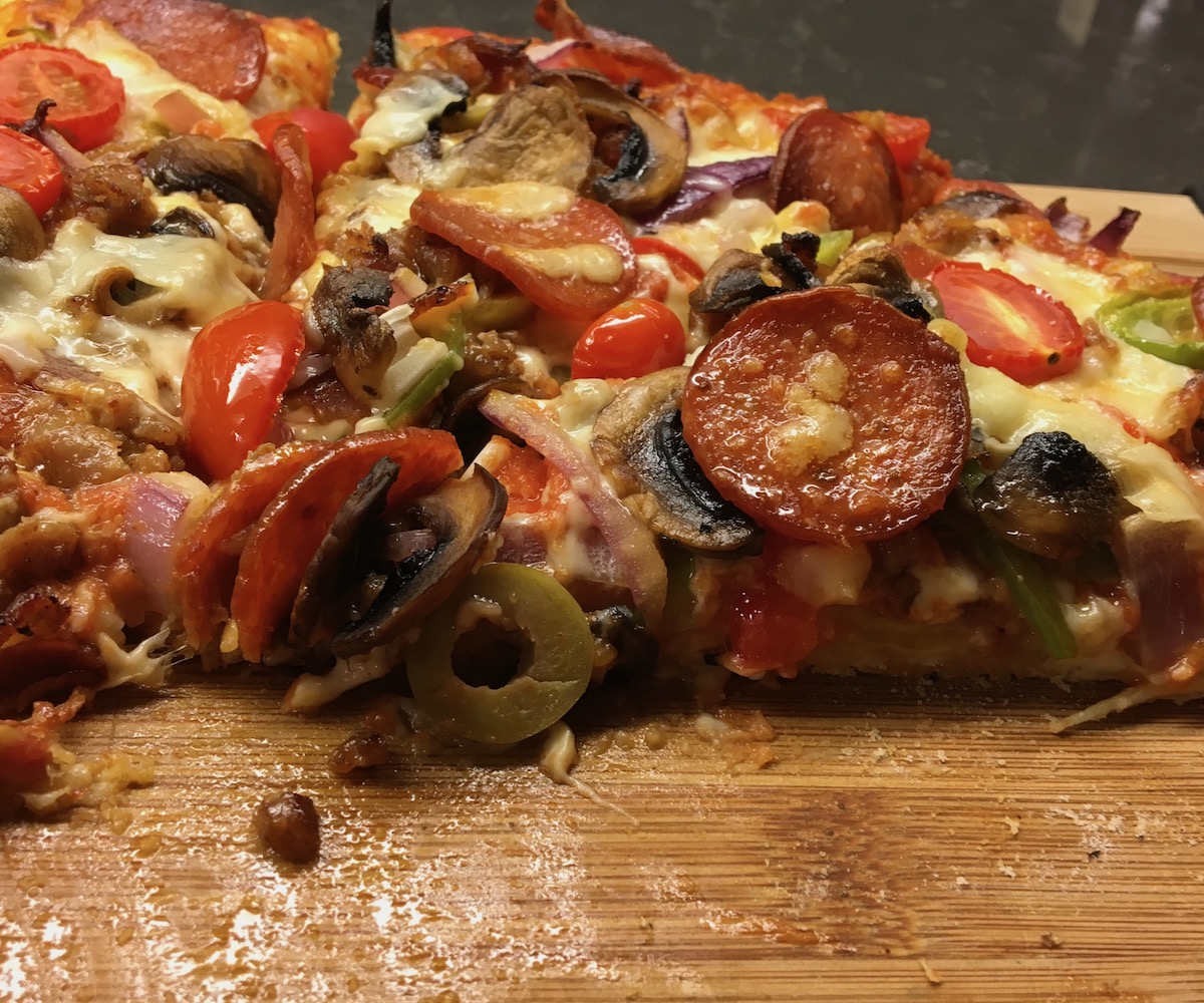 Freshly sliced deluxe pizza.